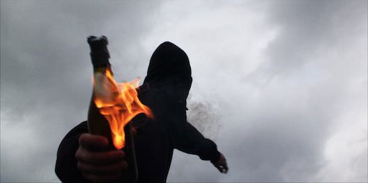 A reenactment from 'Informant' of a man throwing a molotov cocktail. Courtesy Jamie Meltzer