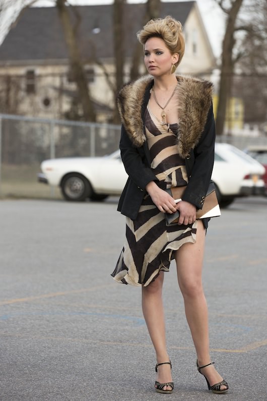 Rosalyn Rosenfeld (Jennifer Lawrence) outside the Long Island elementary school. Her dress, jacket, jewelry, shoes, & bag are vintage.