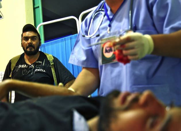 There were many desperate days when the field hospitals beds were always full. Here a fighter watches as his friend is treated for battle wounds in a Misrata field hospital. Photo by Rachel Beth Anderson.