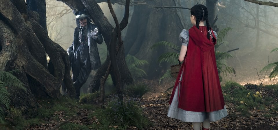 Johnny Depp as the Wolf and Lilla Crawford as Little Red Riding Hood in Disney's humorous and heartfelt musical INTO THE WOODS, directed by Rob Marshall and produced by John Deluca, Rob Marshall, Marc Platt and Callum McDougall.
