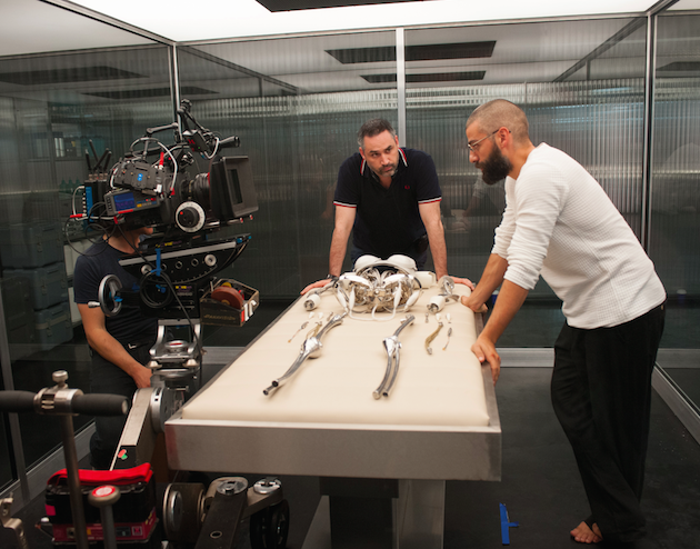 DP Rob Hardy, Garland and Isaac stand over Ava's robotic skeleton. Courtesy A24.