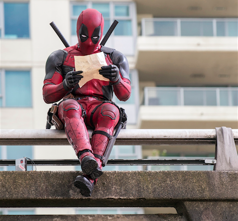 Deadpool (Ryan Reynolds) catching up on some reading before battle. Photo by David Dolseo. Courtesy 20th Century Fox.