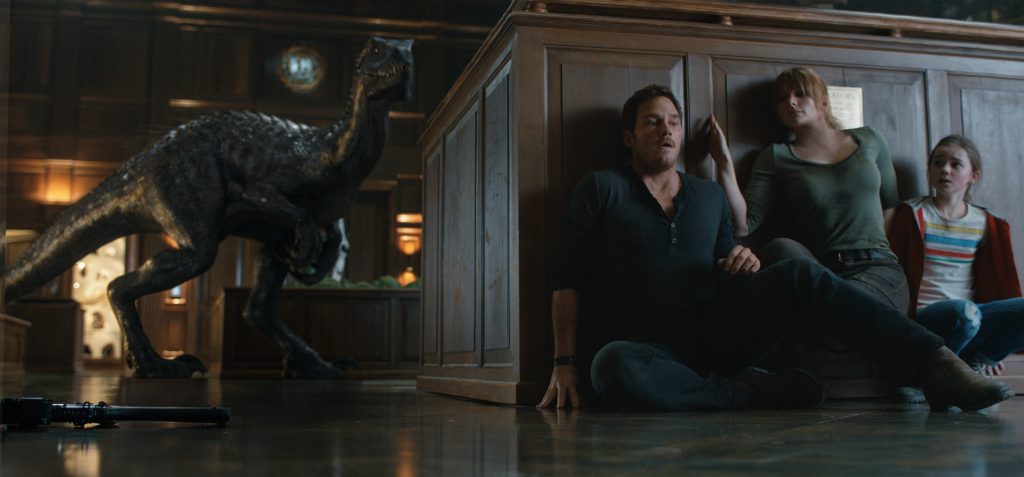 The Indoraptor stalks its prey—(L to R) Owen (CHRIS PRATT), Claire (BRYCE DALLAS HOWARD) and Maisie (ISABELLA SERMON) in "Jurassic World: Fallen Kingdom." When the island's dormant volcano begins roaring to life, Owen and Claire (Bryce Dallas Howard) mount a campaign to rescue the remaining dinosaurs from this extinction-level event. Welcome to "Jurassic World: Fallen Kingdom." Photo Credit: Universal Studios and Amblin Entertainment, Inc. and Legendary Pictures Productions, LLC.