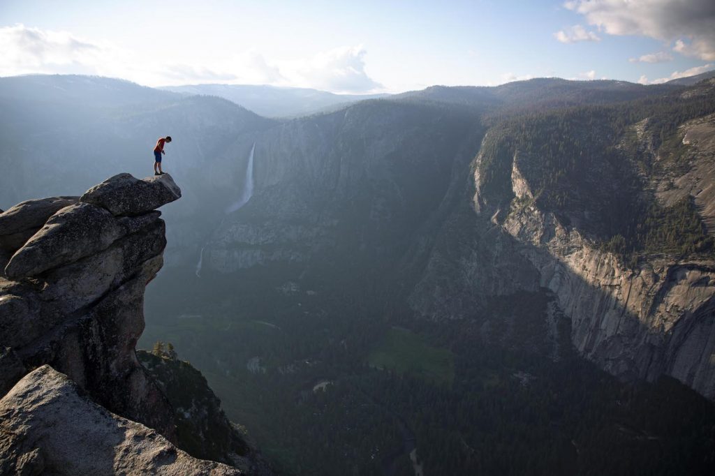 Alex Honnold peers over the edge of Glacier Point in Yosemite National Park. He had just climbed 2000 feet up from the valley floor. National Geographic/Jimmy Chin.