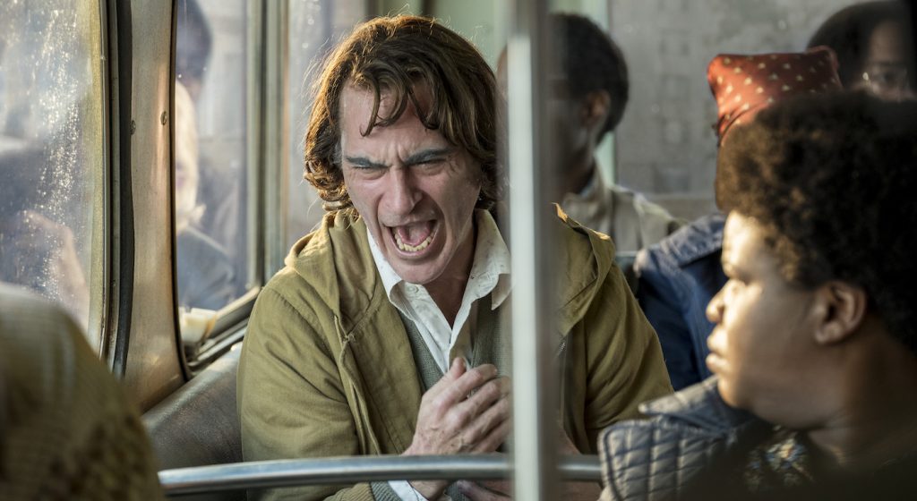 Caption: (Center) JOAQUIN PHOENIX as Arthur Fleck in Warner Bros. Pictures, Village Roadshow Pictures and BRON Creative’s tragedy “JOKER,” a Warner Bros. Pictures release. Photo Credit: Niko Tavernise. Copyright: © 2019 Warner Bros. Entertainment Inc.