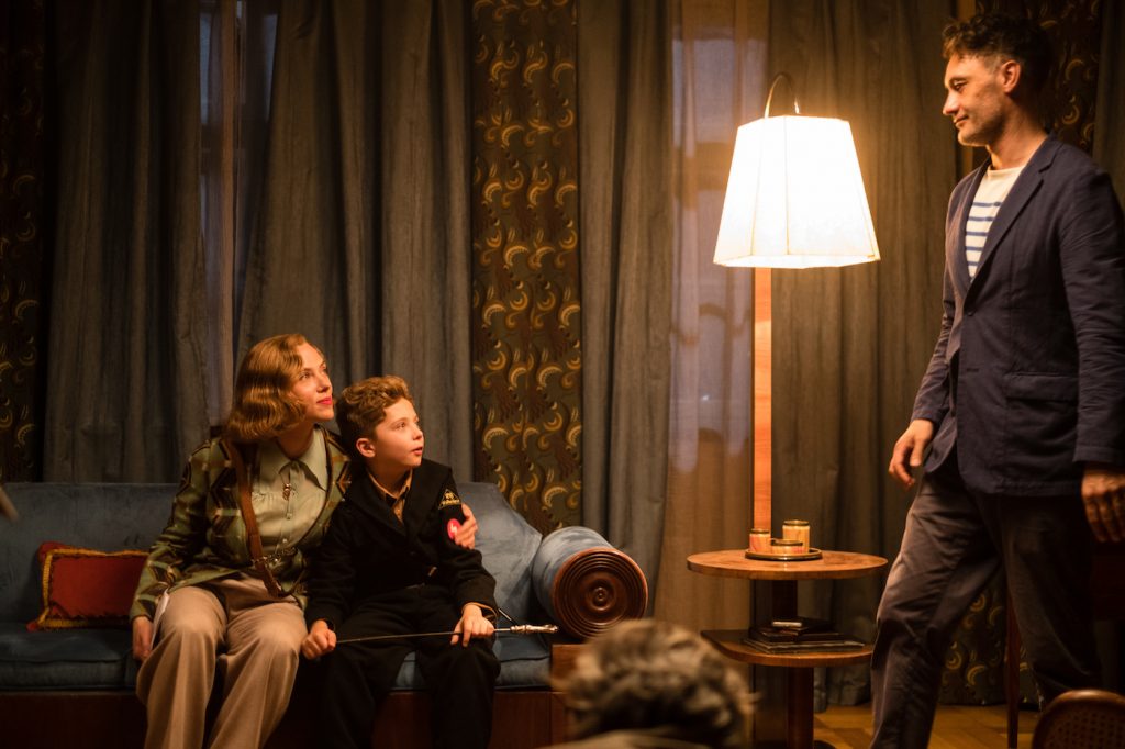 (From L-R): Scarlett Johansson, Roman Griffin Davis and Writer/Director Taika Waititi on the set of JOJO RABBIT. Photo by Kimberley French. © 2019 Twentieth Century Fox Film Corporation All Rights Reserved