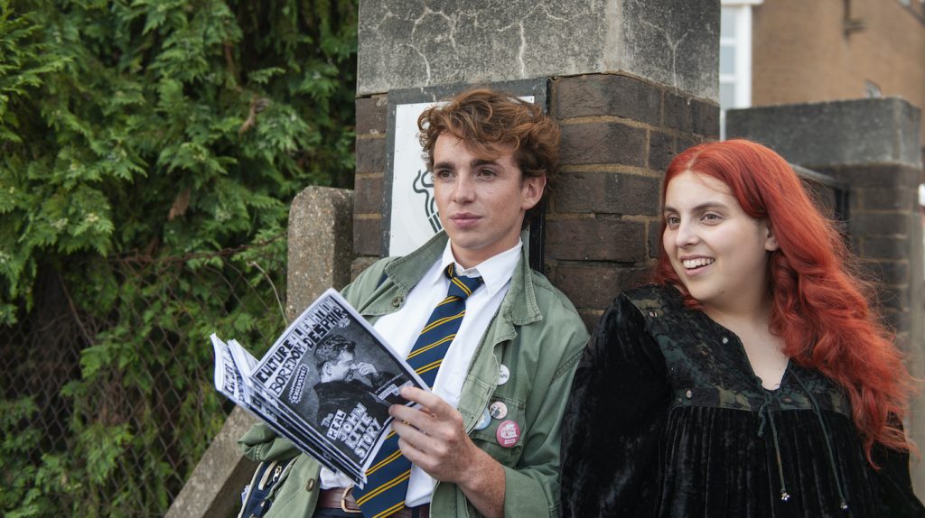 Laurie Kynaston as “Krissi Morrigan” and Beanie Feldstein as “Johanna Morrigan” in Coky Giedroyc’s HOW TO BUILD A GIRL. Courtesy of IFC Films. An IFC Films Release.