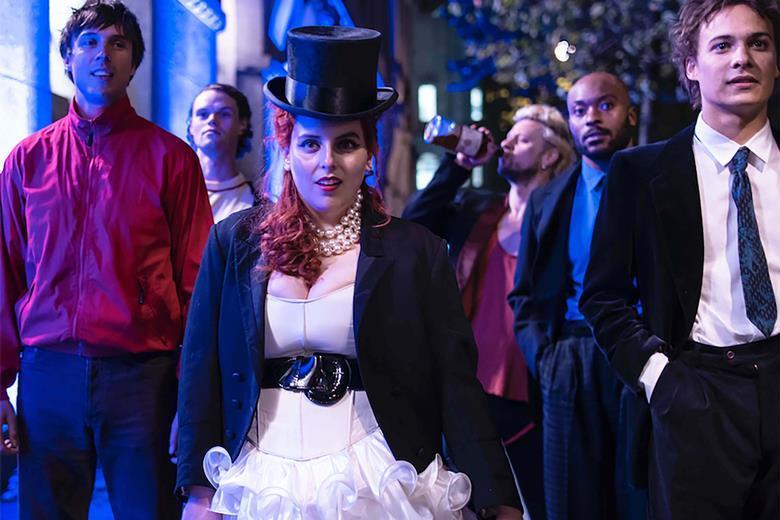 Beanie Feldstein as “Johanna Morrigan” and Cast in Coky Giedroyc’s HOW TO BUILD A GIRL. Courtesy of IFC Films. An IFC Films Release.