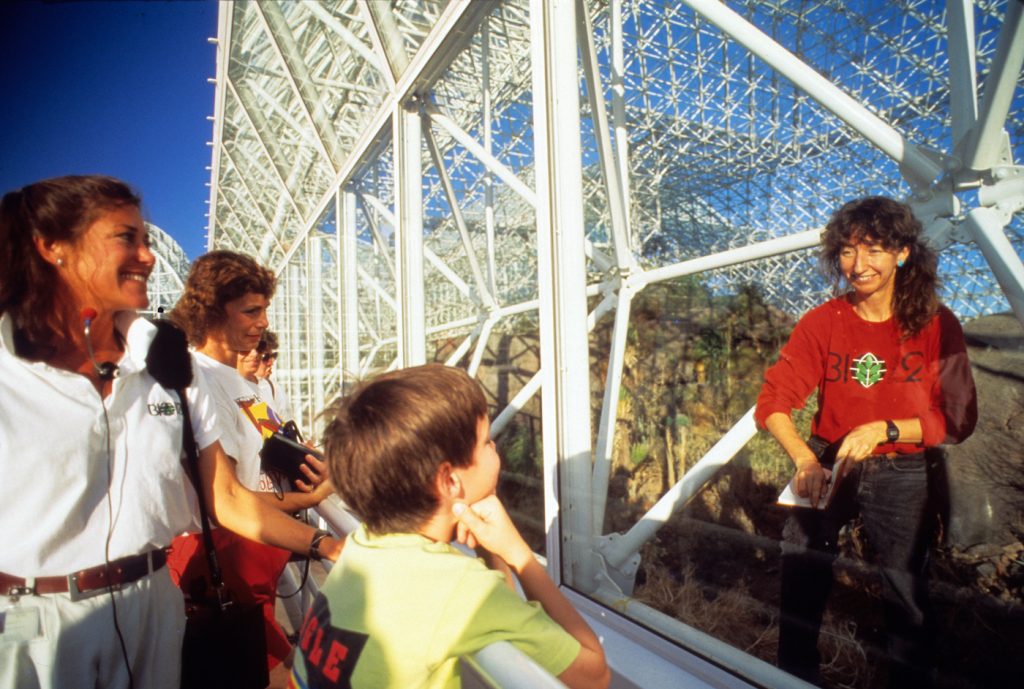 Linda Leigh and tourists interacting from either side of the Biosphere. Courtesy of NEON