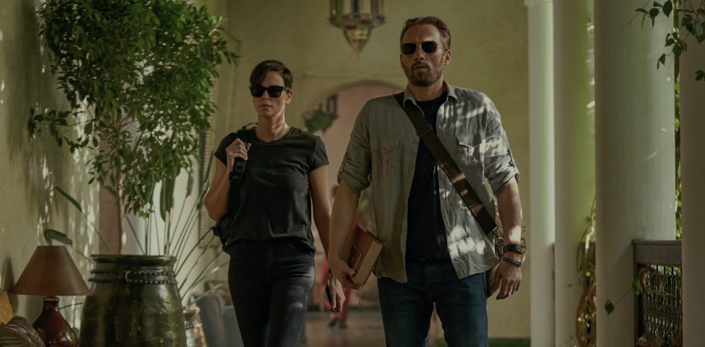 THE OLD GUARD (L to R) CHARLIZE THERON as ANDY and MATTHIAS SCHOENAERTS as BOOKER in THE OLD GUARD. Cr. AIMEE SPINKS/NETFLIX © 2020