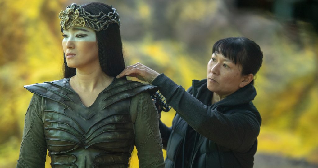 Hair and makeup head Denise Kum works on Li Gong (Xianniang) behind the scenes of Disney's MULAN. Photo credit: Jasin Boland. © 2020 Disney Enterprises, Inc. All Rights Reserved.