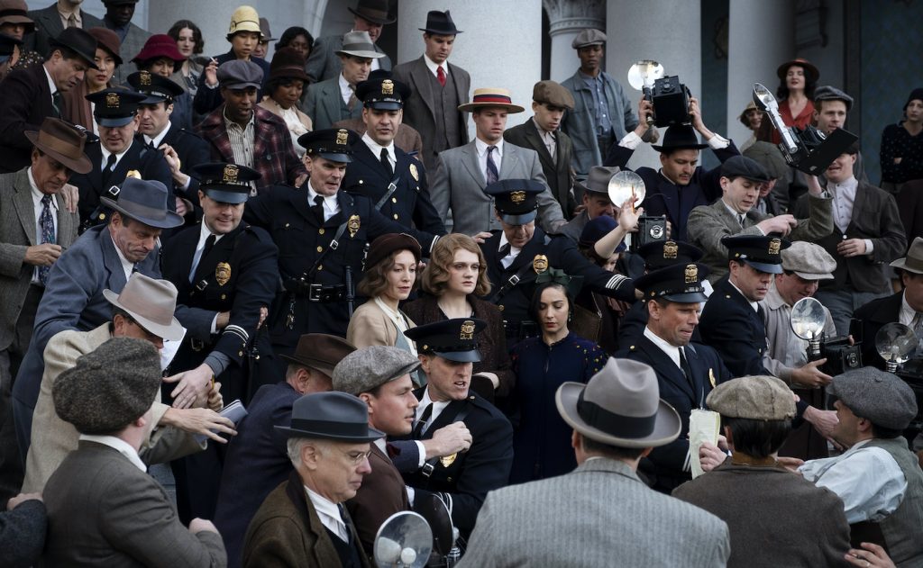 Actors Juliet Rylance (Della Street) and Gayle Rankin (Emily Dodson) make their way down the L.A. City Hall’s west façade steps, passing through a mob of 200 protestors. Background cast must mime their shouts and jeers when the camera rolls, to allow the sound recorder to clearly record the principal cast’s lines. Courtesy HBO