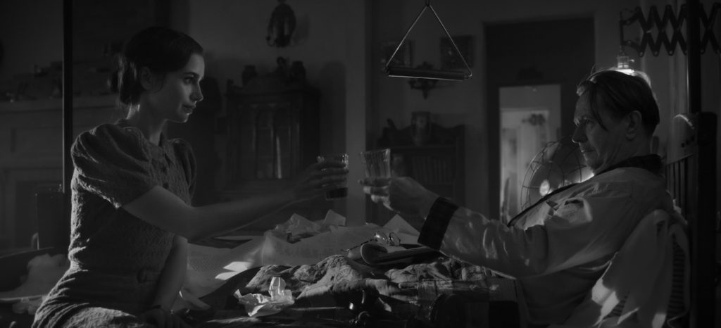 MANK (2020) Lily Collins as Rita Alexander and Gary Oldman as Herman Mankiewicz. Cr. Netflix.
