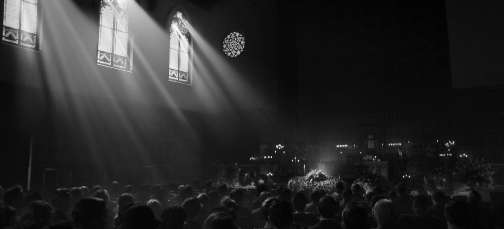 Massive location scene depicting the funeral of MGM production boss Irving Thalberg. Note the dim interior, struck by grand light shafts coming in through the synagogue windows, courtesy of gaffer Danny Gonzalez (Photo: © 2020 Netflix, Inc.)