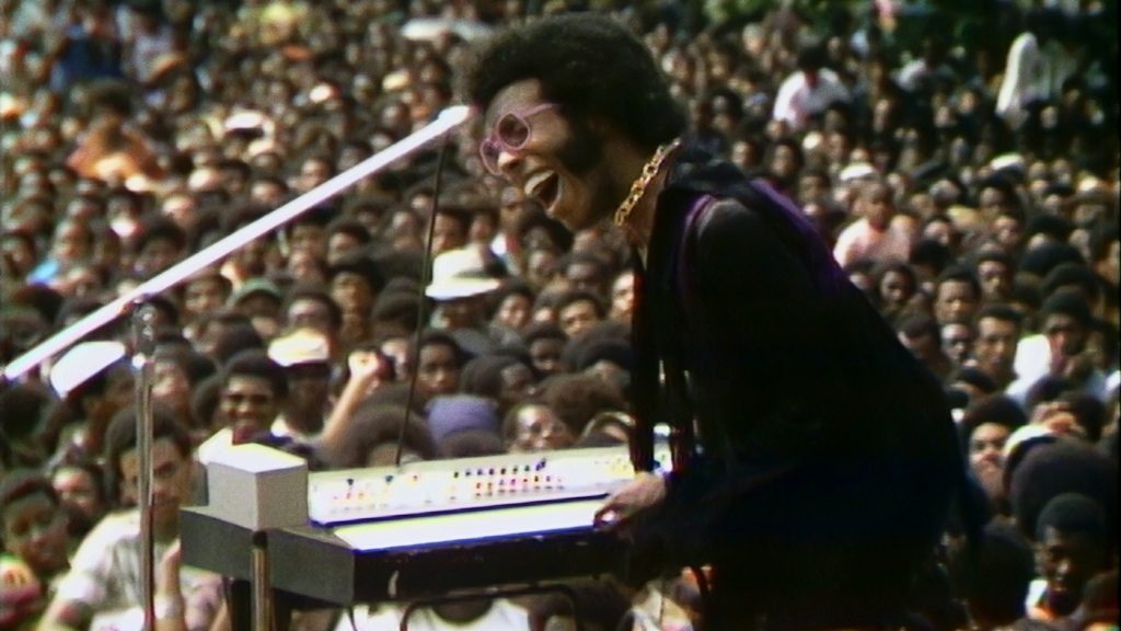 Sly Stone performing at the Harlem Cultural Festival in 1969, featured in the documentary SUMMER OF SOUL. Photo Courtesy of Searchlight Pictures. © 2021 20th Century Studios All Rights Reserved