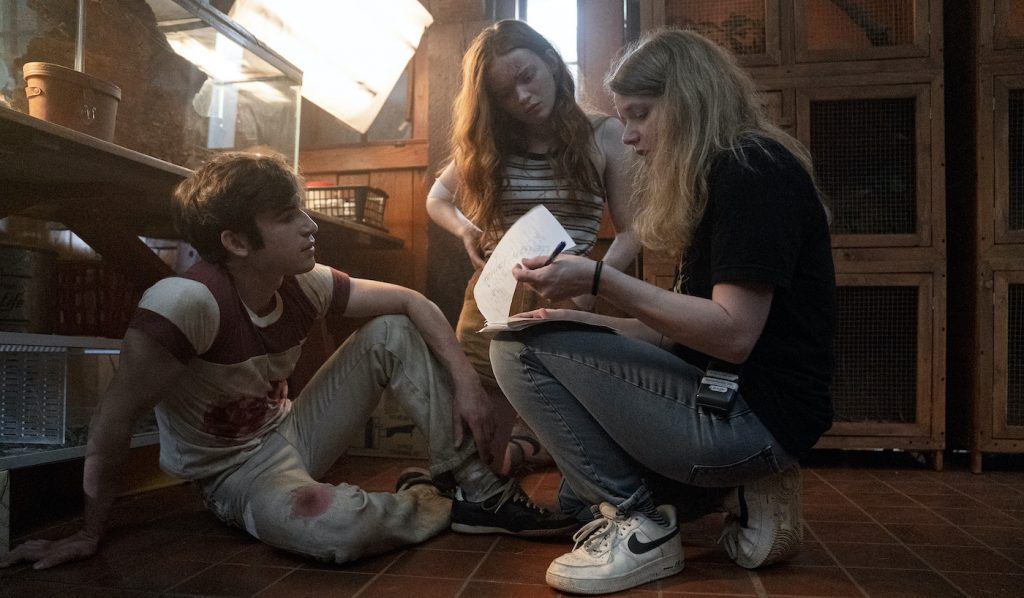 Fear Street Part 2: 1978 - (L-R) BTS of TED SUTHERLAND as NICK and SADIE SINK as ZIGGY and Director Leigh Janiak. Cr: Jessica Miglio/Netflix © 2021