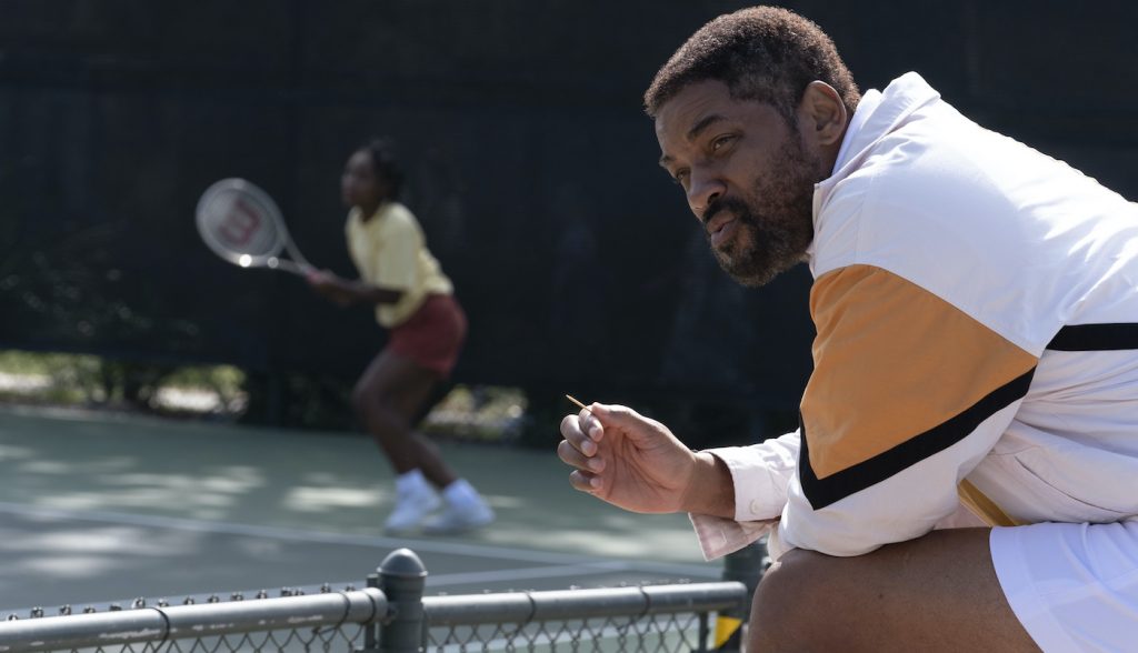 Caption: (L background-r) SANIYYA SIDNEY as Venus Williams and WILL SMITH as Richard Williams in Warner Bros. Pictures’ inspiring drama “KING RICHARD,” a Warner Bros. Pictures release. Photo Credit: Chiabella James
