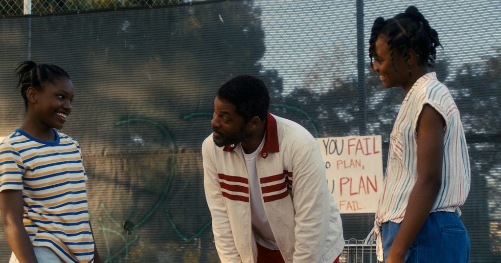Caption: (L-r) DEMI SINGLETON as Serena Williams, WILL SMITH as Richard Williams and SANIYYA SIDNEY as Venus Williams in Warner Bros. Pictures’ inspiring drama “KING RICHARD,” a Warner Bros. Pictures release. Photo Credit: Courtesy of Warner Bros. Pictures