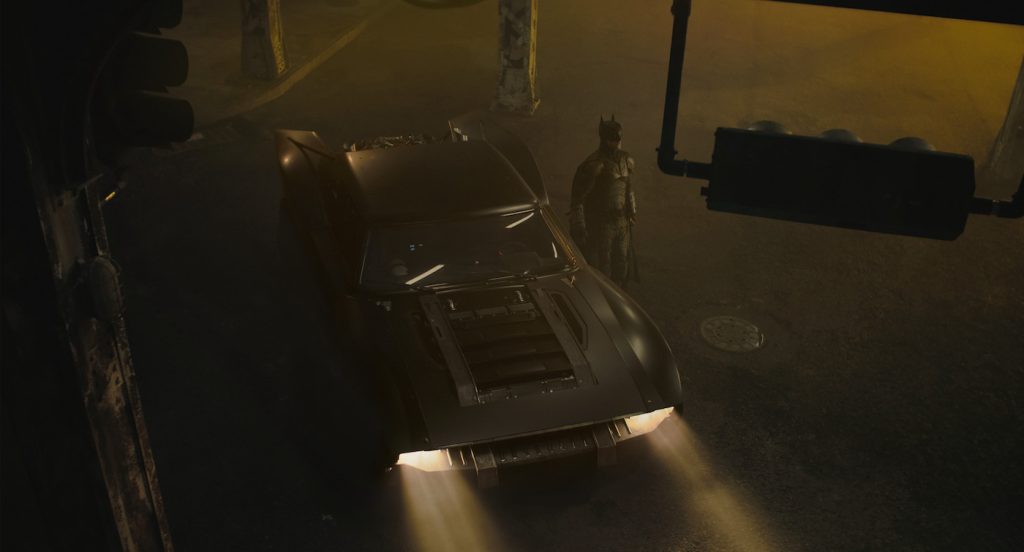 Caption: ROBERT PATTINSON as Batman with the Batmobile in a scene in Warner Bros. Pictures’ action adventure “THE BATMAN,” a Warner Bros. Pictures release. Photo Credit: Warner Bros. Pictures/ ™ & © DC Comics