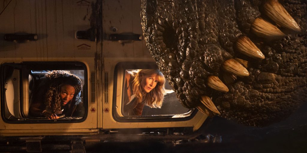 (from left) Kayla Watts (DeWanda Wise), Dr. Ellie Sattler (Laura Dern) and a Giganotosaurus in Jurassic World Dominion. Courtesy Universal Pictures.