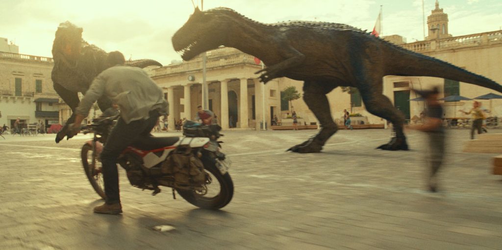 (from left) An Allosaurus, Owen Grady (Chris Pratt) and a Carnotaurus in Jurassic World Dominion. Courtesy Universal Pictures.