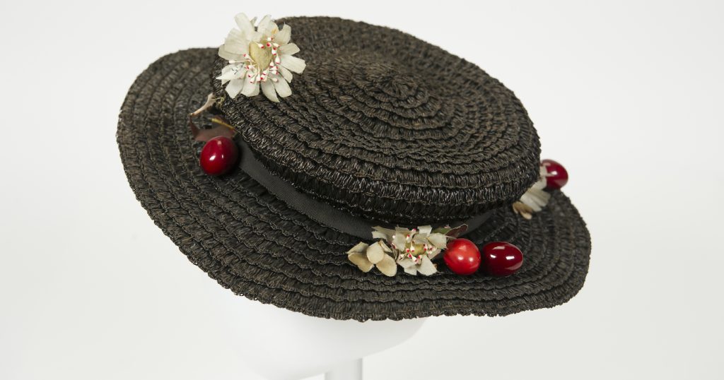 Mary Poppins Hat. This is one of the hats worn by Julie Andrews in Mary Poppins (1964). Walt Disney Archives staff members found the piece in the Disney Studio’s Wardrobe Department just a few short years ago. It is a black straw hat with faux cherries and flower blossoms, and was featured in the film as part of Mary’s instantly recognizable “traveling costume.”