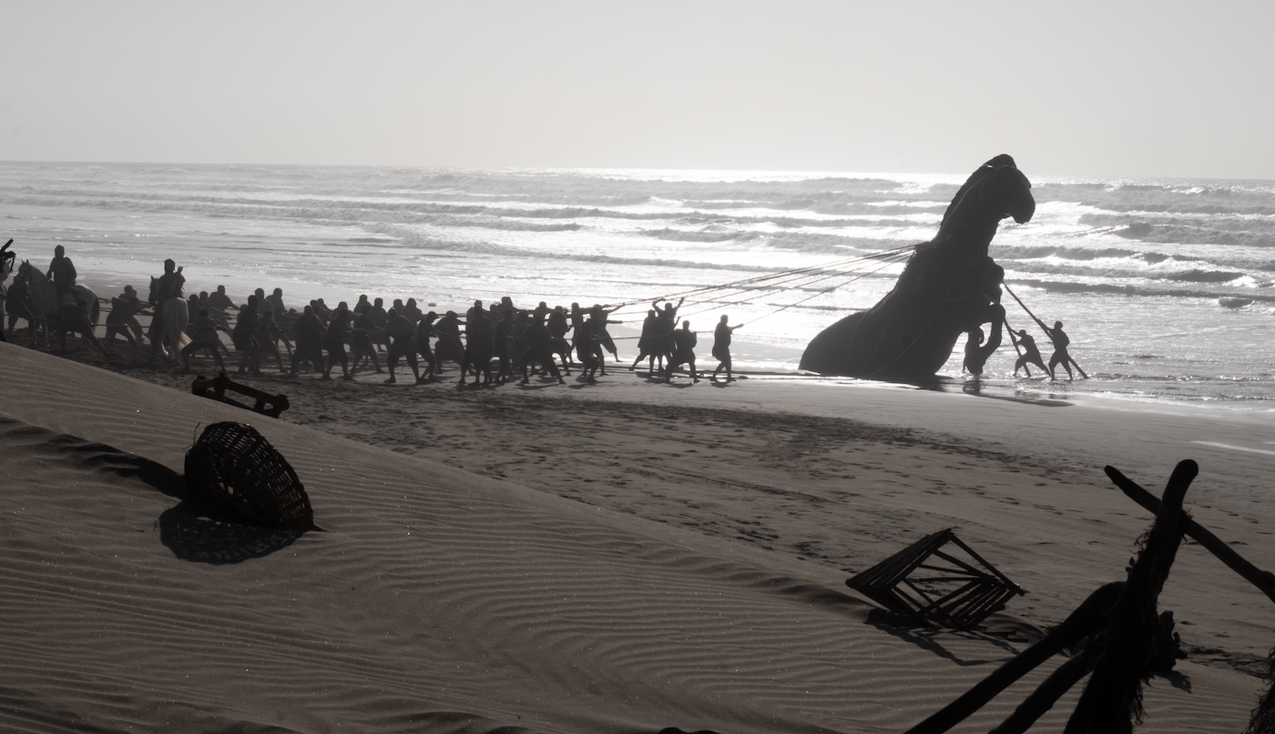Cavalo de Troia sendo levado pela praia em A Odisseia